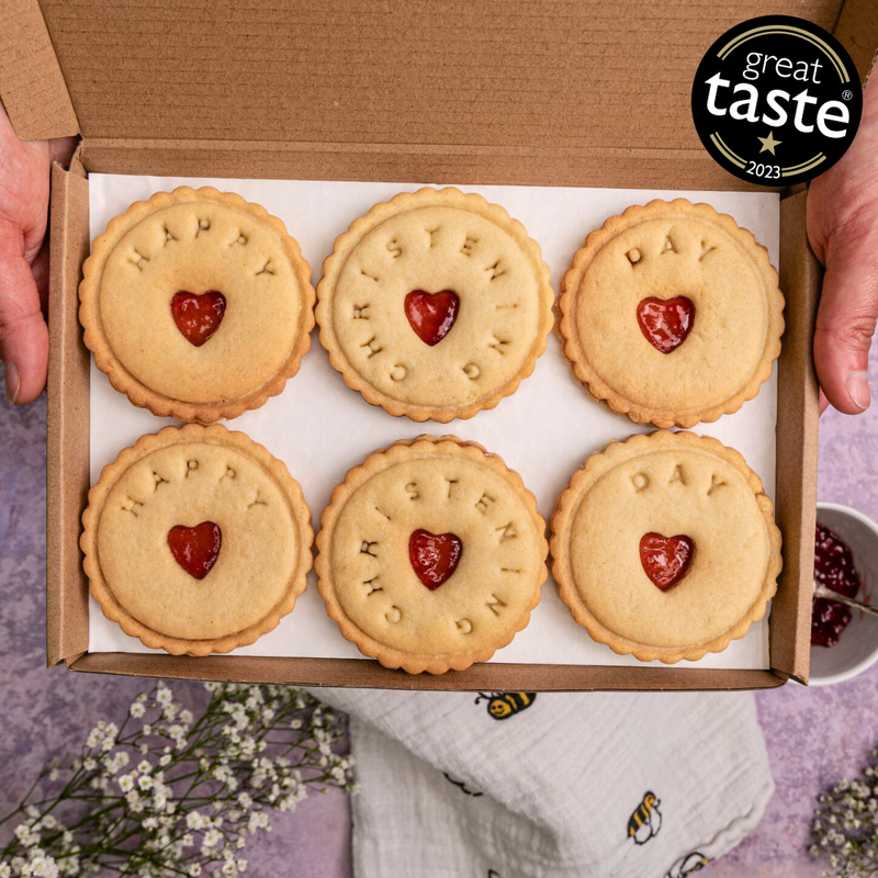 A box of six heart-shaped biscuits with 'Happy Christening Day' written on them