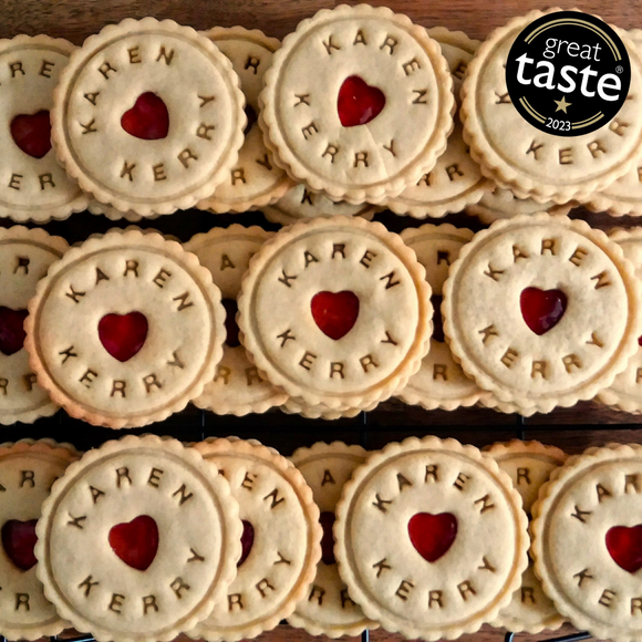 Close-up of Custom Wedding Names Biscuits with heart-shaped holes, stacked on a wooden table 