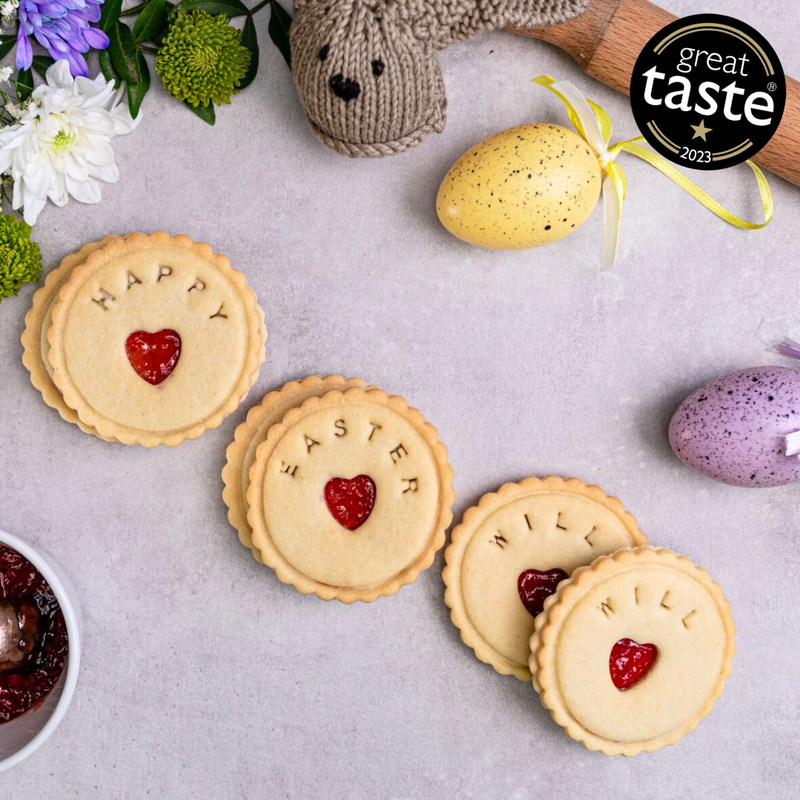 A box of Personalised Easter biscuits with the text "Happy Easter " written on them. The box is sitting on a table.