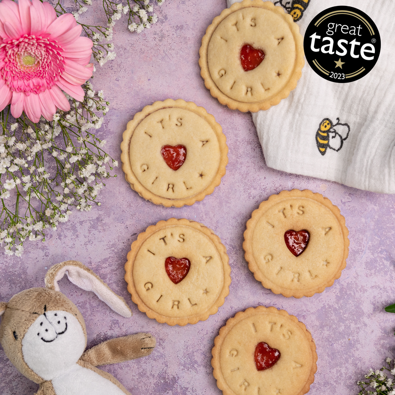 The biscuits with jam filling proudly announce: 'It's a girl!' Handmade treats for welcoming the new baby.