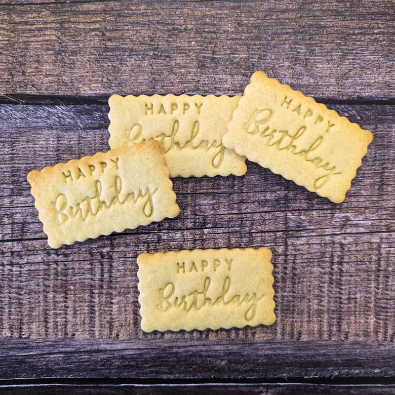 Five 'Happy Birthday' cookies on a wooden surface
