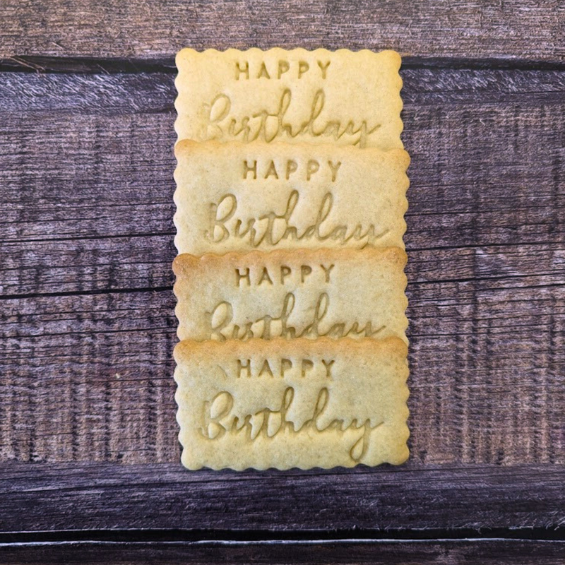 Stack of cookies with 'Happy Birthday' text on a wooden surface