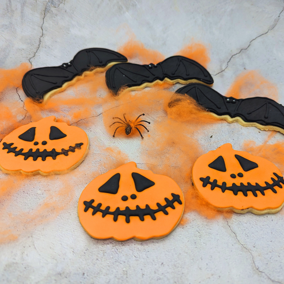 Iced Bat & Pumpkin Party Pack of Halloween biscuits in the shape of pumpkins and bats, decorated with black and orange icing.