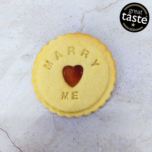 Proposal 'Marry Me' Jam Biscuit: Personalised Gift from the Biskery. The biscuit has a heart shape cut out of it.