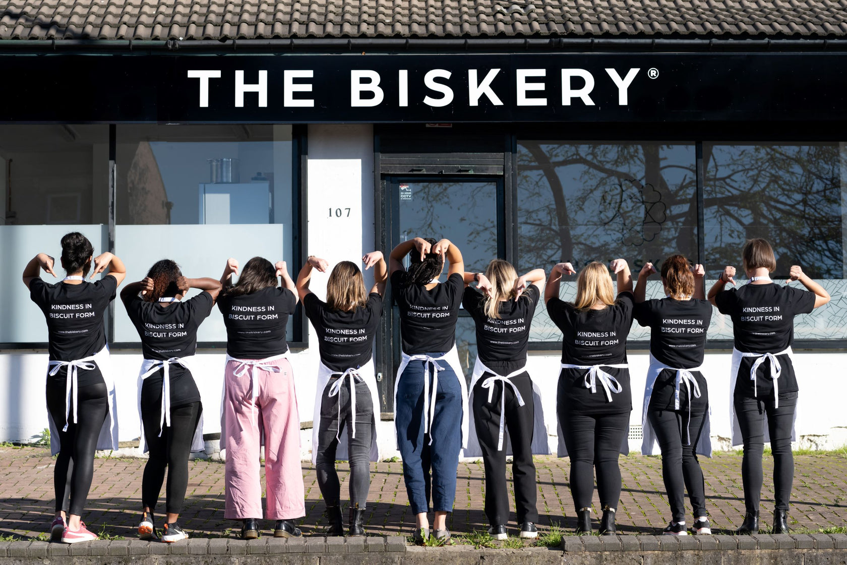 The Biskery employees lined up wearing their Kindness in Biscuit form T-shirts