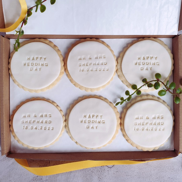 Decorated biscuits adorned with the words "Happy wedding day!" and a personalised date, representing a thoughtful gift for a couple on their special day