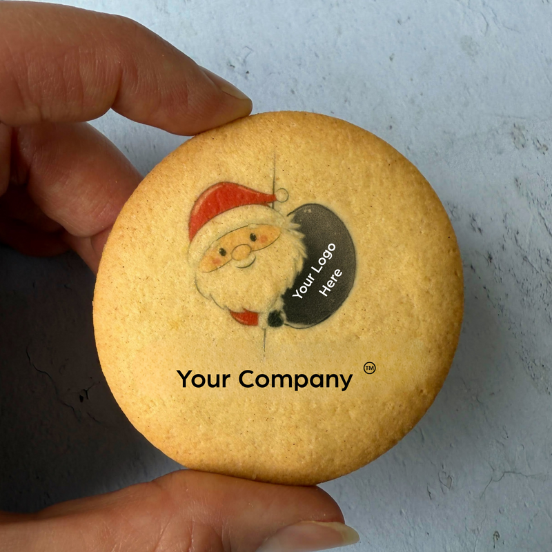 Cookie with Santa Claus illustration and 'Your Company' text held by a hand against a light background