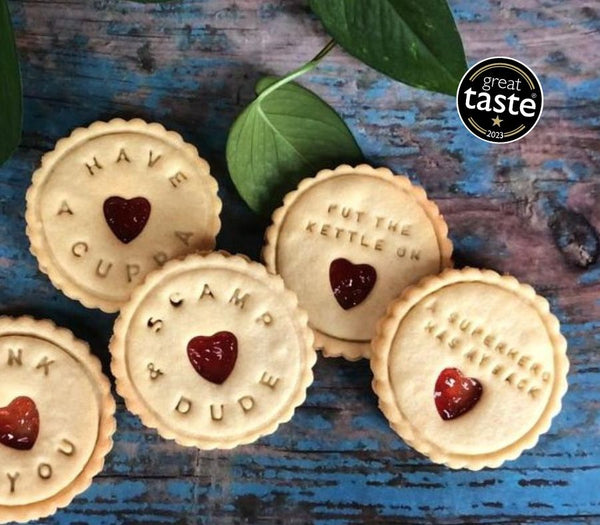 Image of a group of Jammie Dodgers biscuits with hearts on them, arranged on a wooden table.