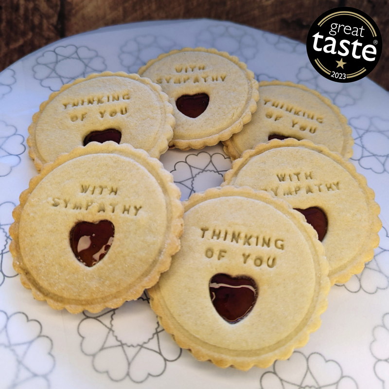 Cookies with 'Thinking of You' and 'With Sympathy' text on a decorative plate.