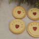 Close-up view of branded jam biscuits from The Biskery company with 'WELCOME', 'BABY', and a personalised name messages