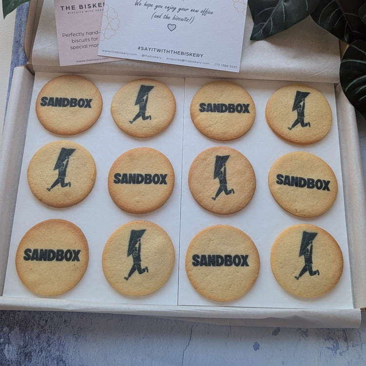 Gift box of 12 butter biscuits printed with Sandbox branding, arranged in three rows of four.