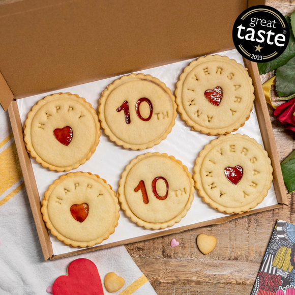 A box of biscuits with the words "Happy Anniversary" written on it. The box is from The Biskery, offering free shipping