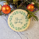 A photo of a Christmas cookie with a festive wreath on it.