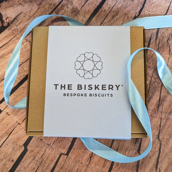 Boxes labelled 'The Biskery' and 'Love Every Bite' sit on a table, filled with Father's Day gift biscuits.