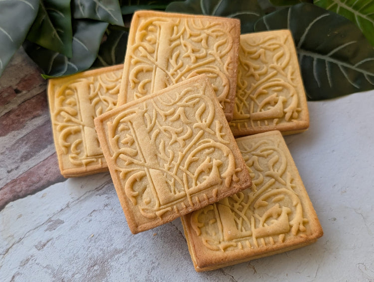 Bespoke square butter biscuits decorated with a debossed intricate pattern.