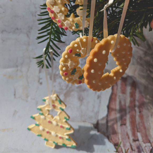 A Christmas tree decorated with a variety of decorated cookies, including gingerbread men. The cookies are hung from the branches of the tree with ribbons