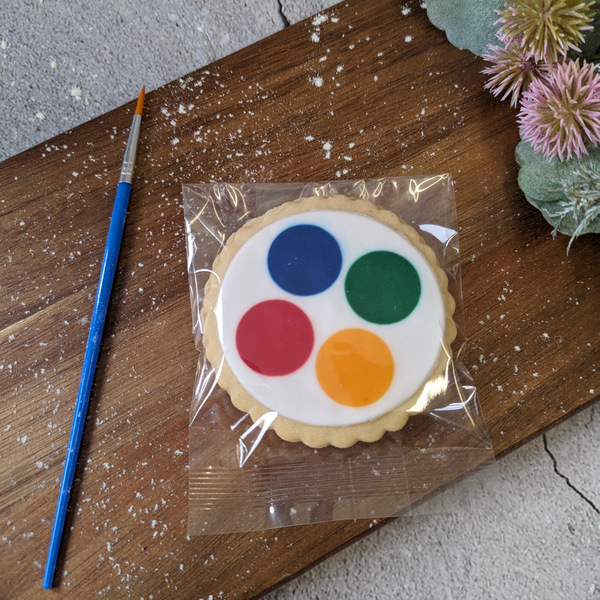 Close-up of a biscuit on a wooden table, next to a paintbrush.
