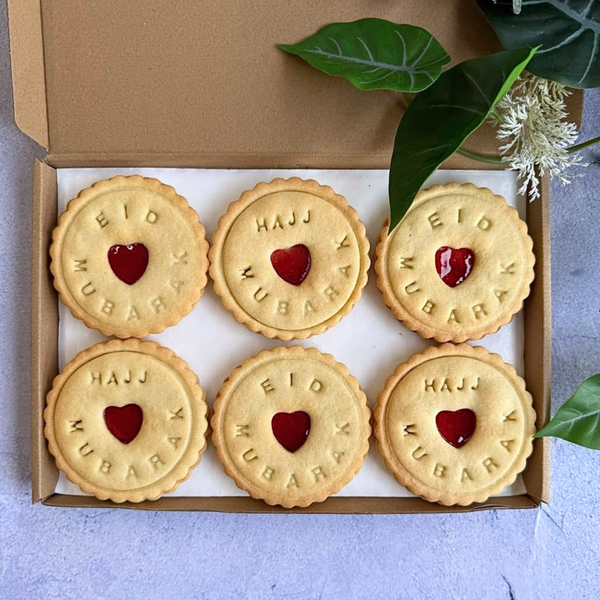 Box of cookies with 'Eid Mubarak' and 'Hajj Mubarak' text on a light background