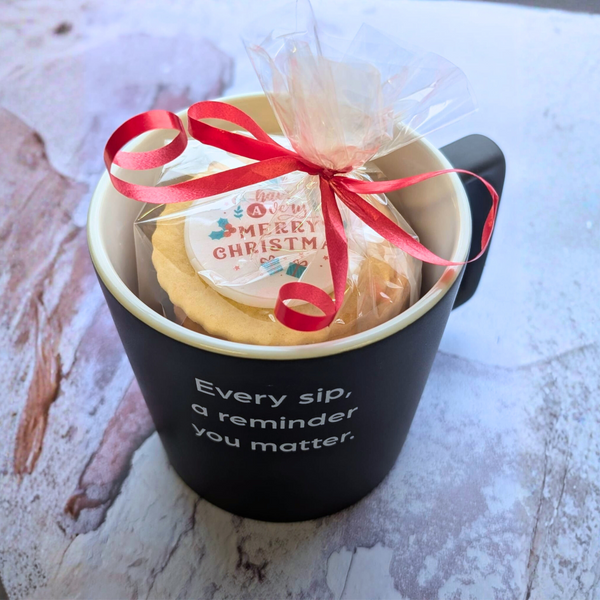 Black 'You Matter' mug with a clear bag of round Biscuits with 'Merry Christmas' topper and red ribbon. Biscuit Cup Gift Set with Jam Biscuits