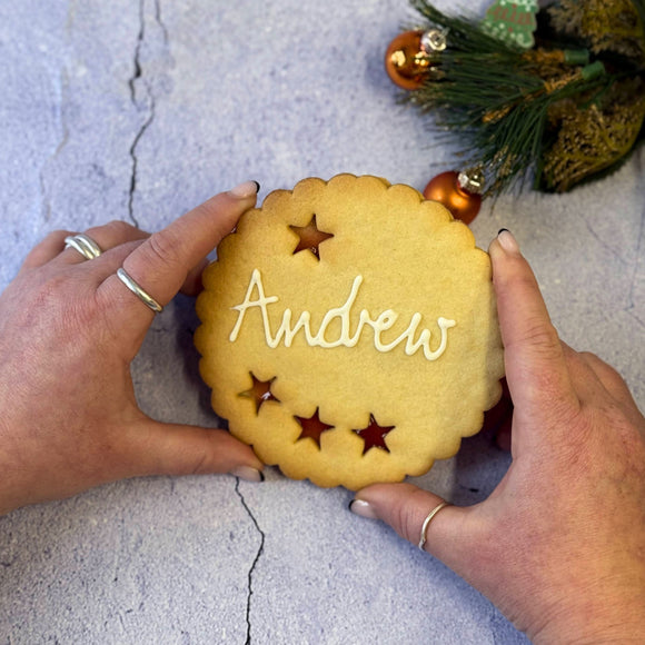 Giant Personalised Christmas Cookie decorated with white icing and the name "Andrew". 