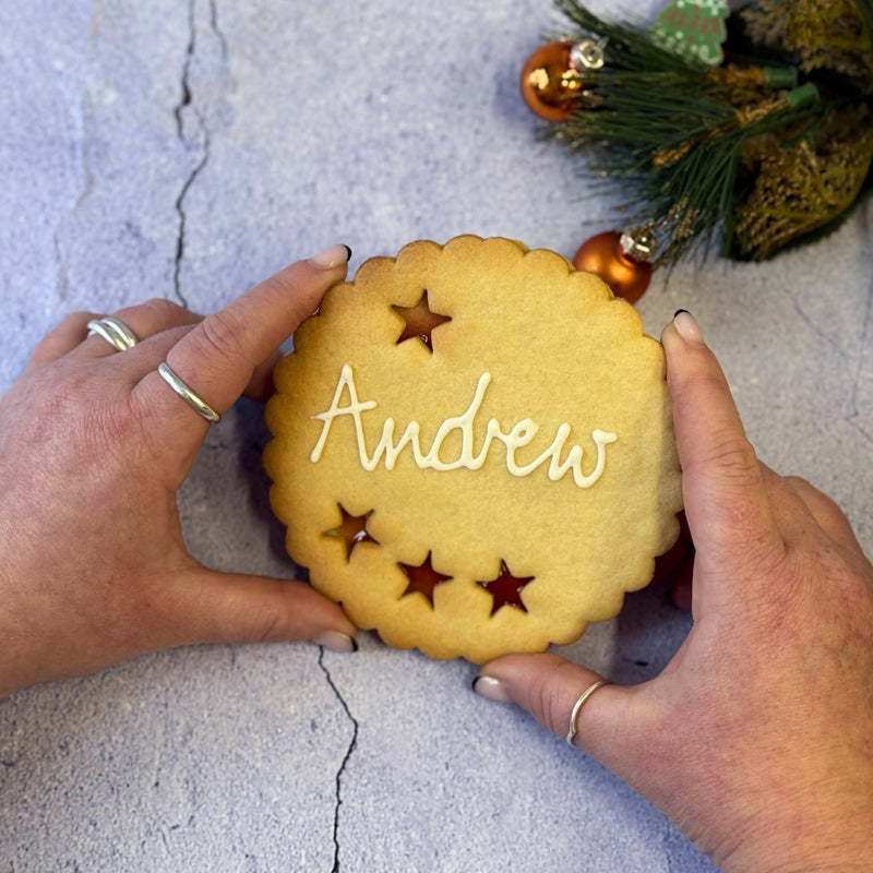 Giant Personalised Christmas Cookie decorated with white icing and the name "Andrew". 