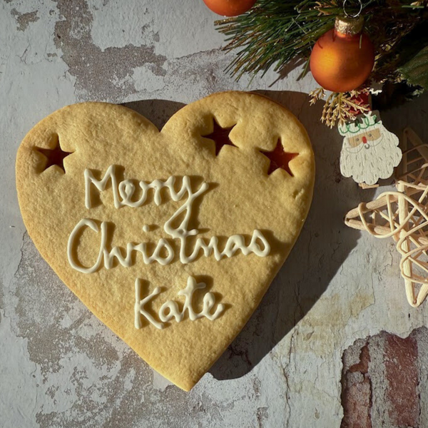 Giant Merry Christmas Cookie with "Merry Christmas Kate" piped in icing and three star-shaped jam cut-outs.