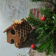 A charming gingerbread house adorned with white icing and gingerbread men, placed on a table next to a delightful pile of biscuits.