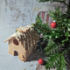 A charming gingerbread house adorned with white icing and gingerbread men, placed on a table next to a delightful pile of biscuits.