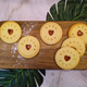 Jam Biscuits with messages on a wooden board with decorative leaves in the background