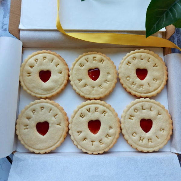 Luxury Happily Ever After Biscuits featuring embossed lettering, red jam hearts, and elegant styling for weddings and romantic gifts in the box.