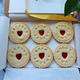 Luxury Happily Ever After Biscuits featuring embossed lettering, red jam hearts, and elegant styling for weddings and romantic gifts in the box.