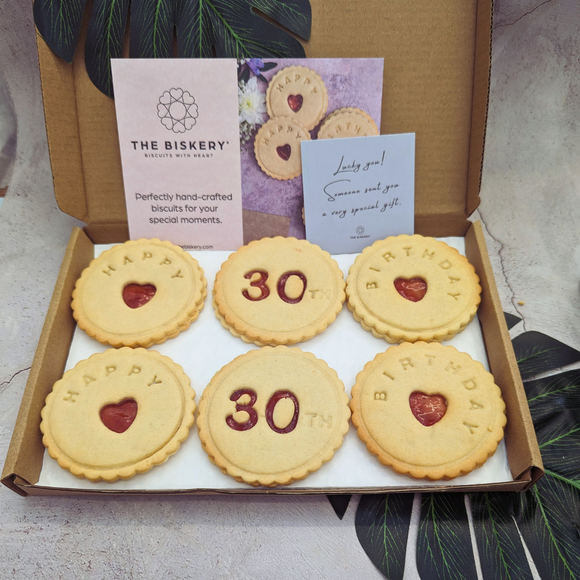 A box of six iced biscuits spelling out "Happy 30th Birthday"