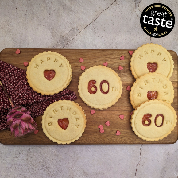 A wooden cutting board topped with delicious biscuits arranged to celebrate a 60th birthday