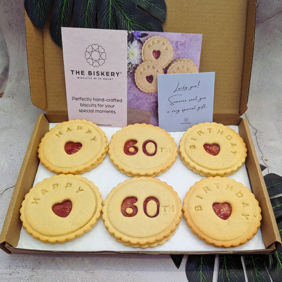 A thoughtful gift of heart-shaped biscuits arranged on a wooden cutting board to celebrate a special 60th birthday.