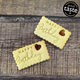 Two jam biscuits that say "Happy Birthday" on a wooden table