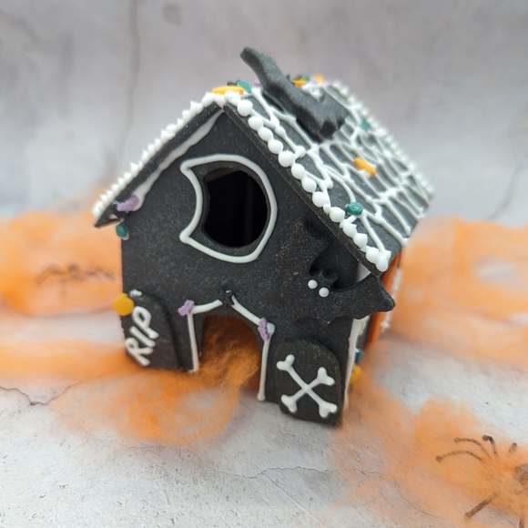 Haunted house decorating DIY kit. Small gingerbread house on a table. Perfect for a spooky Halloween display.