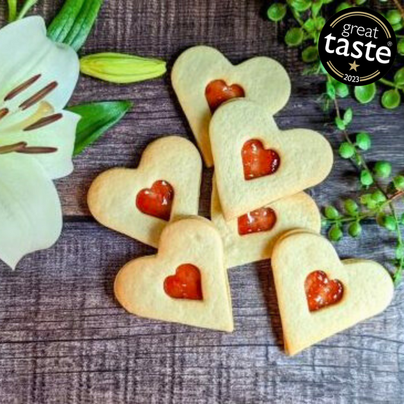 Close-up photo of a heart-shaped sugar cookie with  jam