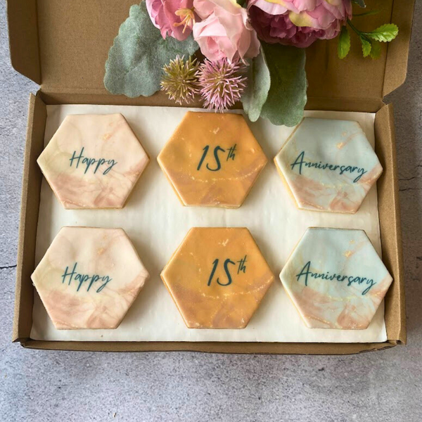 Box of 6 hexagonal iced anniversary biscuits decorated with "Happy Anniversary" messages.