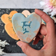 Heart-shaped iced thank you biscuits decorated with a marble-style 'Thank You' message