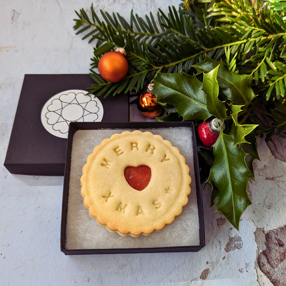 A close-up of a Christmas biscuit with a heart in the middle