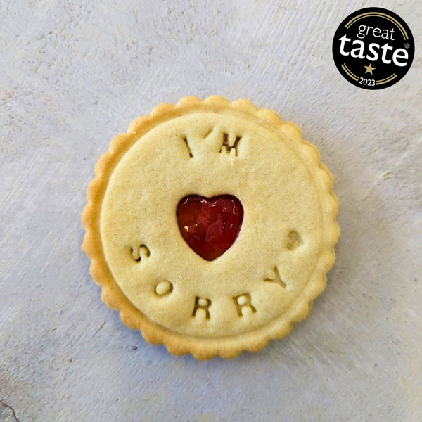 Close-up of a biscuit with a heart-shaped cutout and 'Stay strong' written on it.