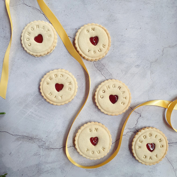 The perfect wedding gift - biscuits decorated with the words 'congrats', 'on your', and 'wedding day' with heart-shaped cut-outs in the middle
