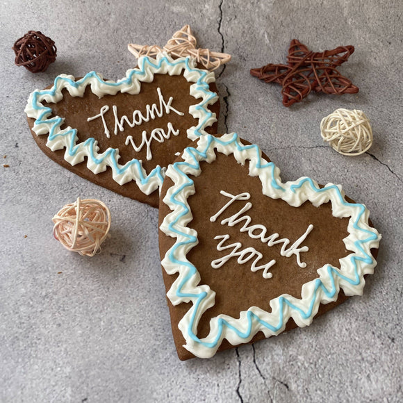 Two heart-shaped Lebkuchen biscuits decorated with icing and sprinkles