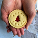 A person holding a cookie in their hands.