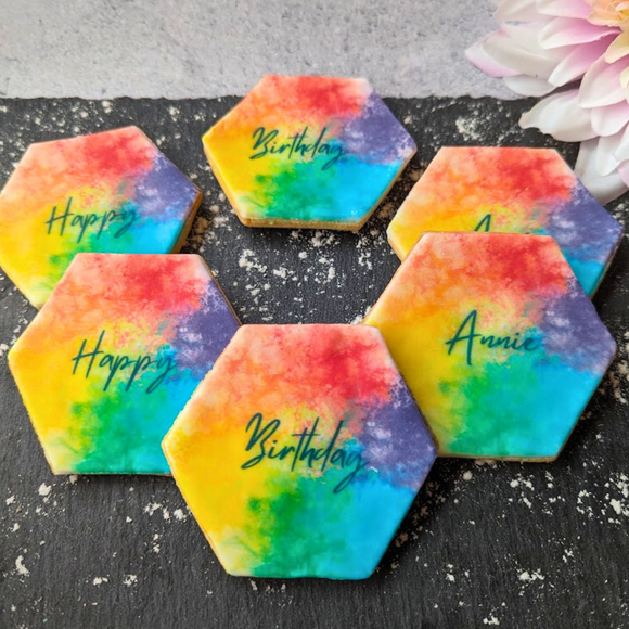 Colourful rainbow biscuits with 'happy Birthday' written on them.