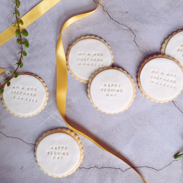 Decorated biscuits with the words "Happy wedding day!" and personalised date, a thoughtful gift for a couple on their special day.