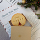 A personalised letter from Santa Claus in a festive envelope, accompanied by a delicious-looking cookie.