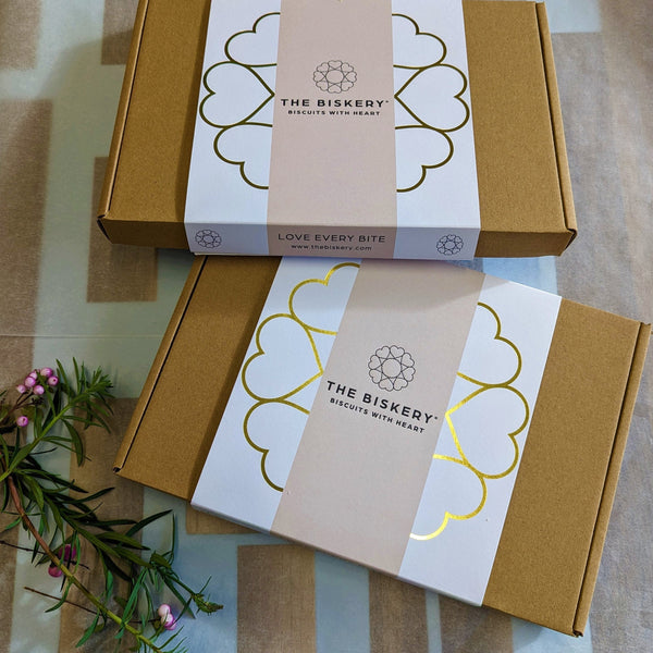 Two letterbox friendly The Biskery gift boxes branded with "Biscuit with heart messaging on them.