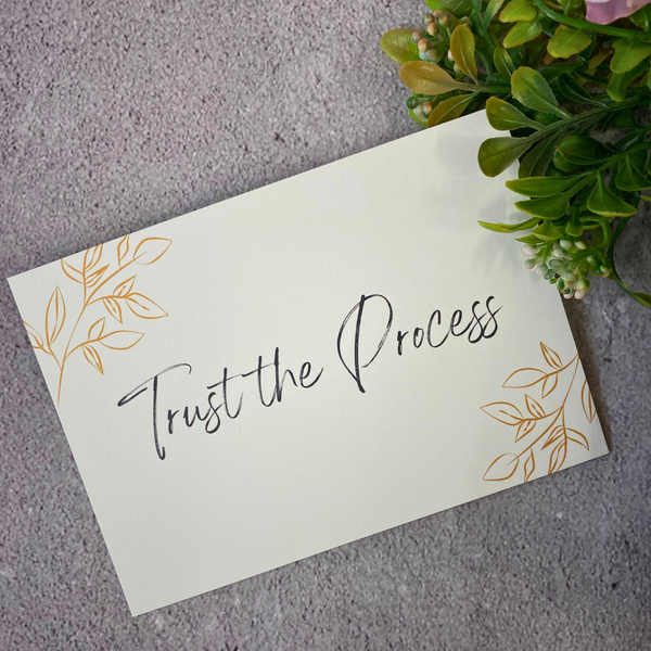 A postcard with 'trust the process' on it.
