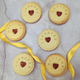 Stack of Jam wedding biscuits with heart-shaped biscuits at the centre, arranged on a table, adorned with a yellow ribbon for the MRS&MRS couple. 